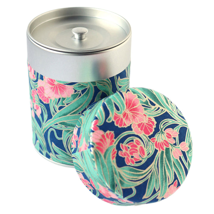 photo packshot d'une boîte à thé cylindrique ouverte tapissée d'un papier japonais aux motifs de fleurs « art nouveau » dans les tons bleu foncé, verts et roses (M947) adeline klam