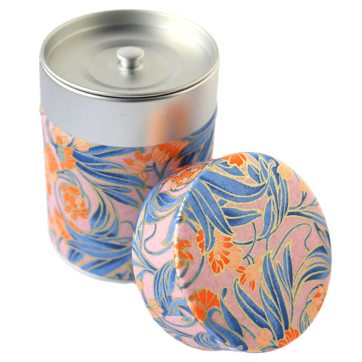 photo packshot d'une boîte à thé cylindrique ouverte tapissée d'un papier japonais aux motifs de fleurs « art nouveau » dans les tons mauve, bleus, corail et dorés (M988) adeline klam