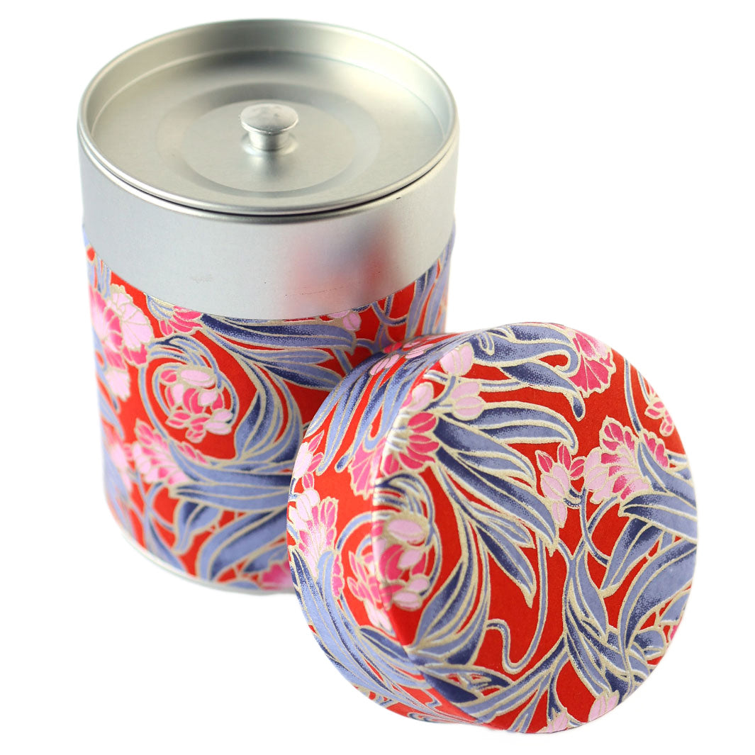 photo packshot d'une boîte à thé cylindrique ouverte tapissée d'un papier japonais aux motifs de fleurs « art nouveau » dans les tons rouges, roses et bleu foncé (M1013) adeline klam