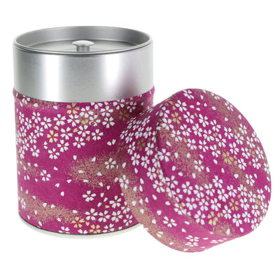 photo packshot d'une boîte à thé cylindrique ouverte tapissée de papier japonais aux motifs de fleurs au vent violet pourpre (M985) adeline klam