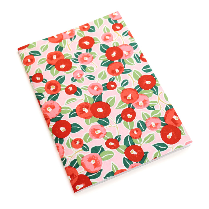 photo packshot d'un carnet habillé de papier japonais au motif de camélias dans les tons rouges, roses et verts (M722) adeline klam