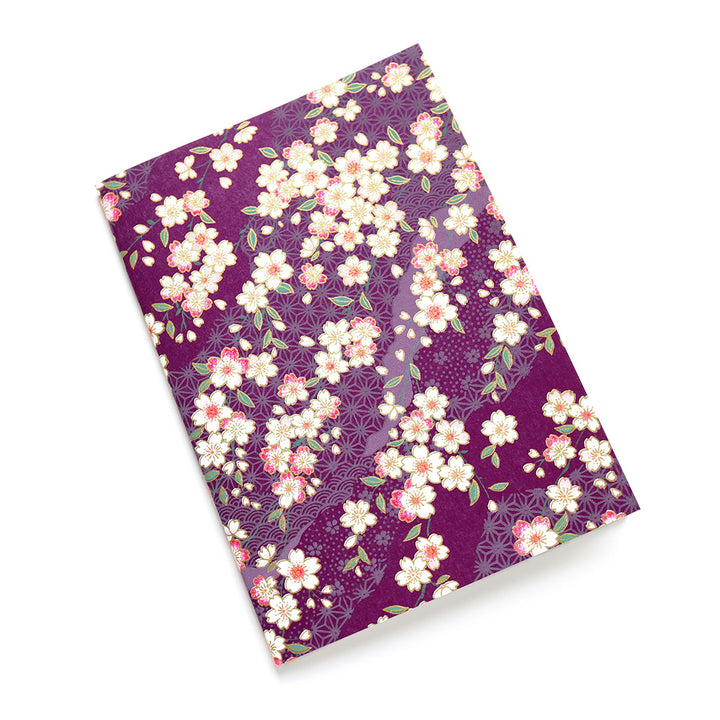 photo packshot d'un carnet habillé de papier japonais aux motifs de fleurs de cerisier et de motifs variés dans les tons prune (M383) adeline klam