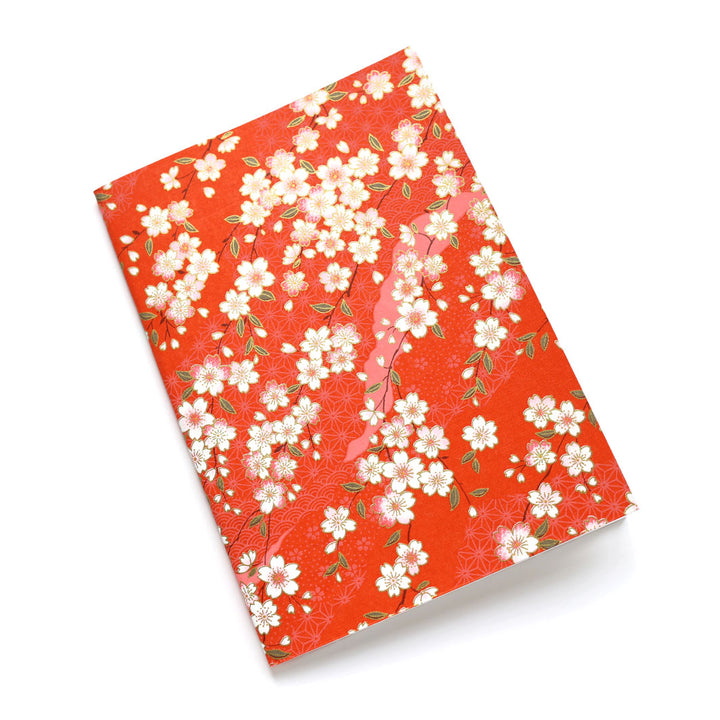 photo packshot d'un carnet habillé de papier japonais aux motifs de fleurs de cerisier et de motifs variés dans les tons rouge orangé (M385) adeline klam