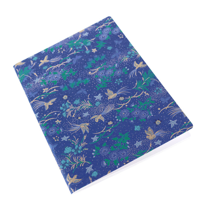 photo packshot d'un carnet de notes tapissé de papier japonais aux motifs de fleurs, d'oiseaux et de papillons dans les tons bleu foncé, verts, mauve, argentés et dorés M992 adeline klam