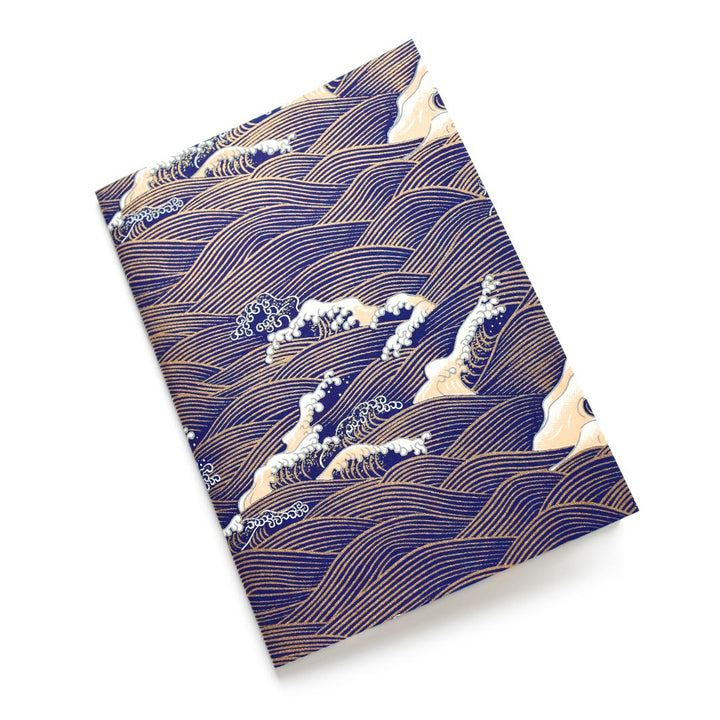 photo packshot d'un carnet habillé de papier japonais aux motifs de vagues et d'écumes dans les tons bleu nuit, jaune clair et dorés (M851) adeline klam