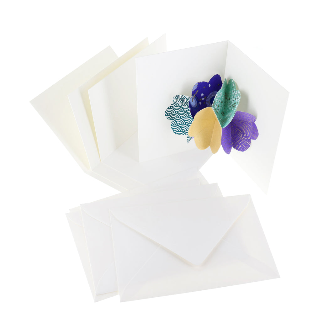 photo packshot d'une carte montée, des cartes doubles vierges et des enveloppes du kit 4 cartes pop-up dans les tons vert d'eau, bleu foncé, violets et dorés « fraîcheur » adeline klam