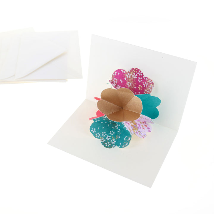 photo packshot d'une carte montée et d'une enveloppe du kit 4 cartes pop-up dans les tons mauve, magenta, bleu canard et dorés « fluorite » adeline klam