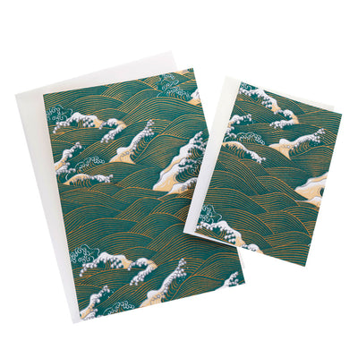 photo packshot de cartes doubles, petits et grands modèles, aux motifs d'envolée de vagues et d'écumes bleu canard, beiges et dorées (M941) adeline klam