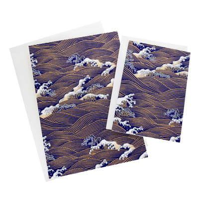 photo packshot de cartes doubles, petits et grands modèles, aux motifs d'envolée de vagues et d'écumes bleu nuit, beiges et dorées (M951) adeline klam
