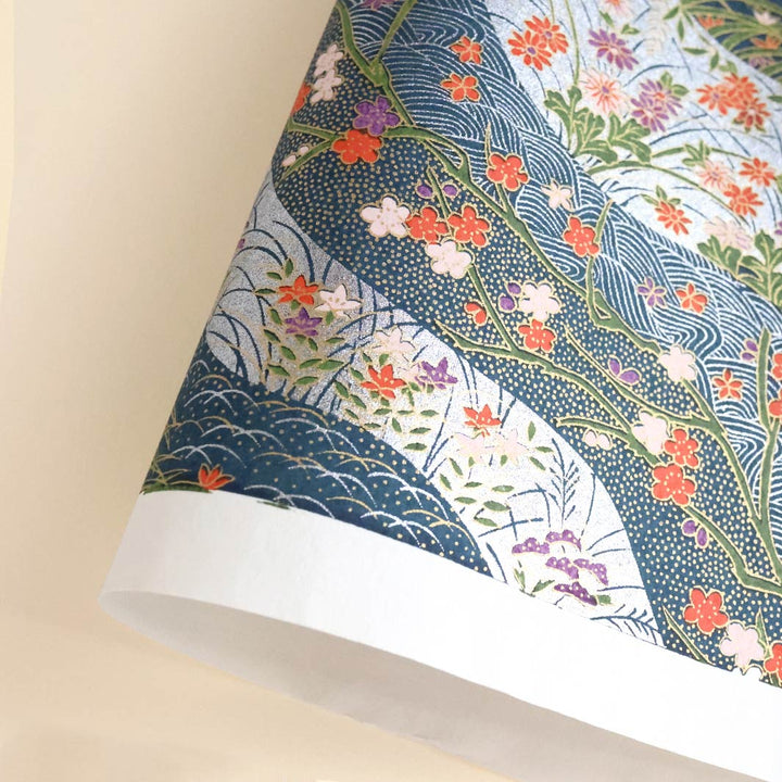 photo packshot d'une courbe de papier japonais yuzen chiyogami aux motifs de dunes et de fleurs dans les tons bleu foncé, rouges, verts et argentés adeline klam (M747)