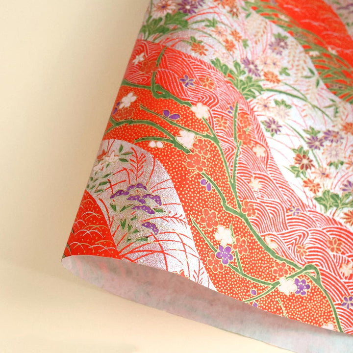 photo packshot d'une courbe de papier japonais yuzen chiyogami aux motifs de dunes et de fleurs dans les tons rouges, verts et argentés adeline klam (M745)
