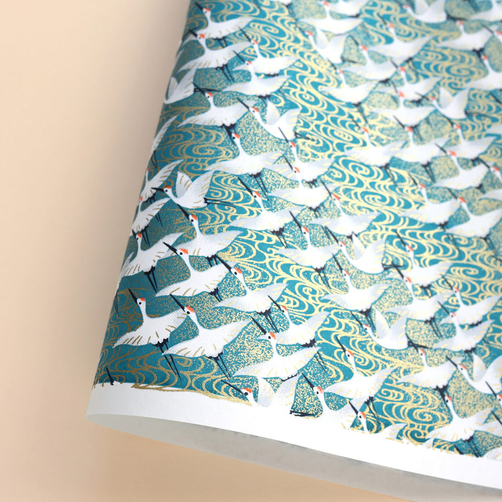 photo packshot d'une courbe du papier japonais yuzen chiyogami aux motifs d'envolée de grues blanches sur fond bleu canard adeline klam (M932)