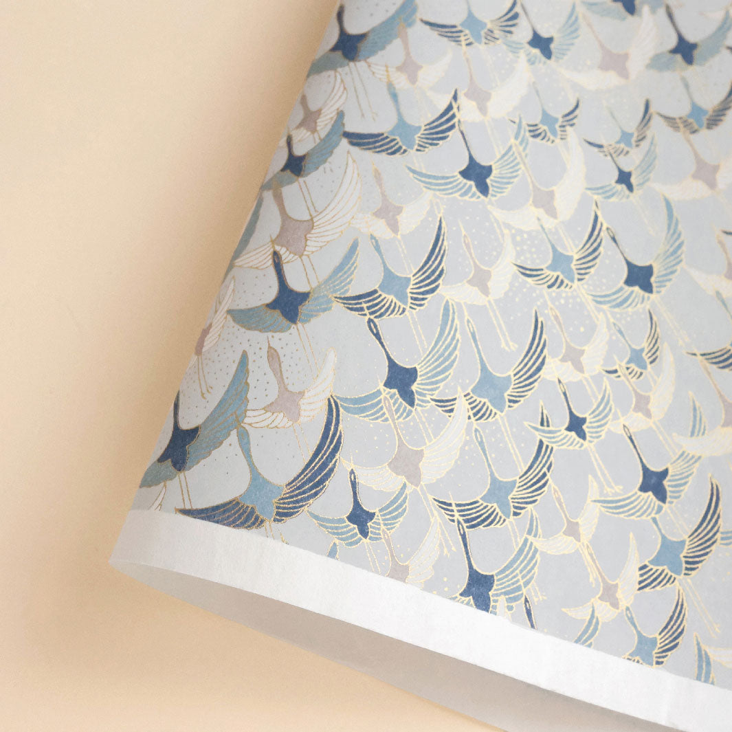photo packshot d'une courbe de papier japonais yuzen chiyogami aux motifs d'envolée de grues « graphiques »dans les tons gris perle, bleus et taupe adeline klam (M753)