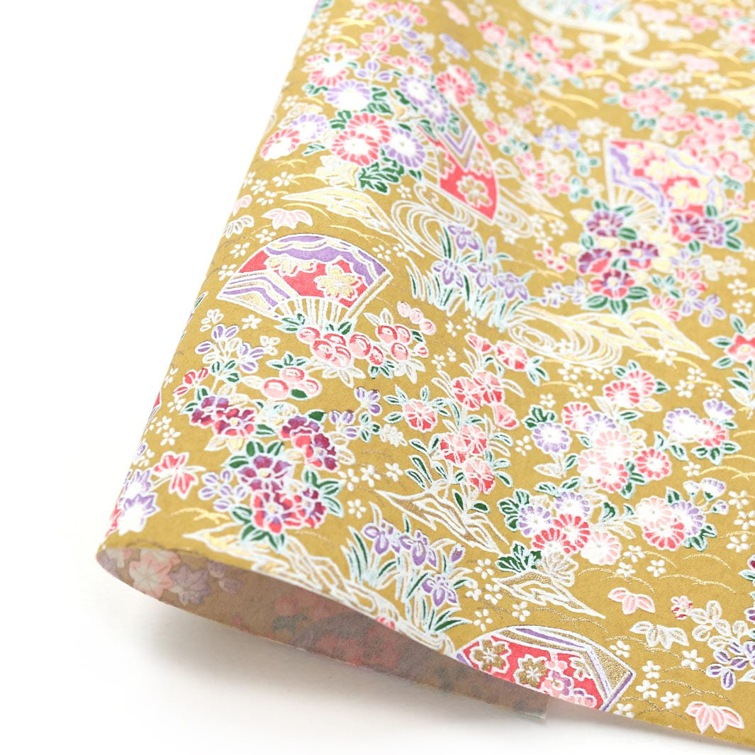 photo packshot d'une courbe de papier japonais yuzen chiyogami aux motifs d'éventails fleuris dans les tons jaune moutarde, roses, violets et vert foncé adeline klam (M1048)