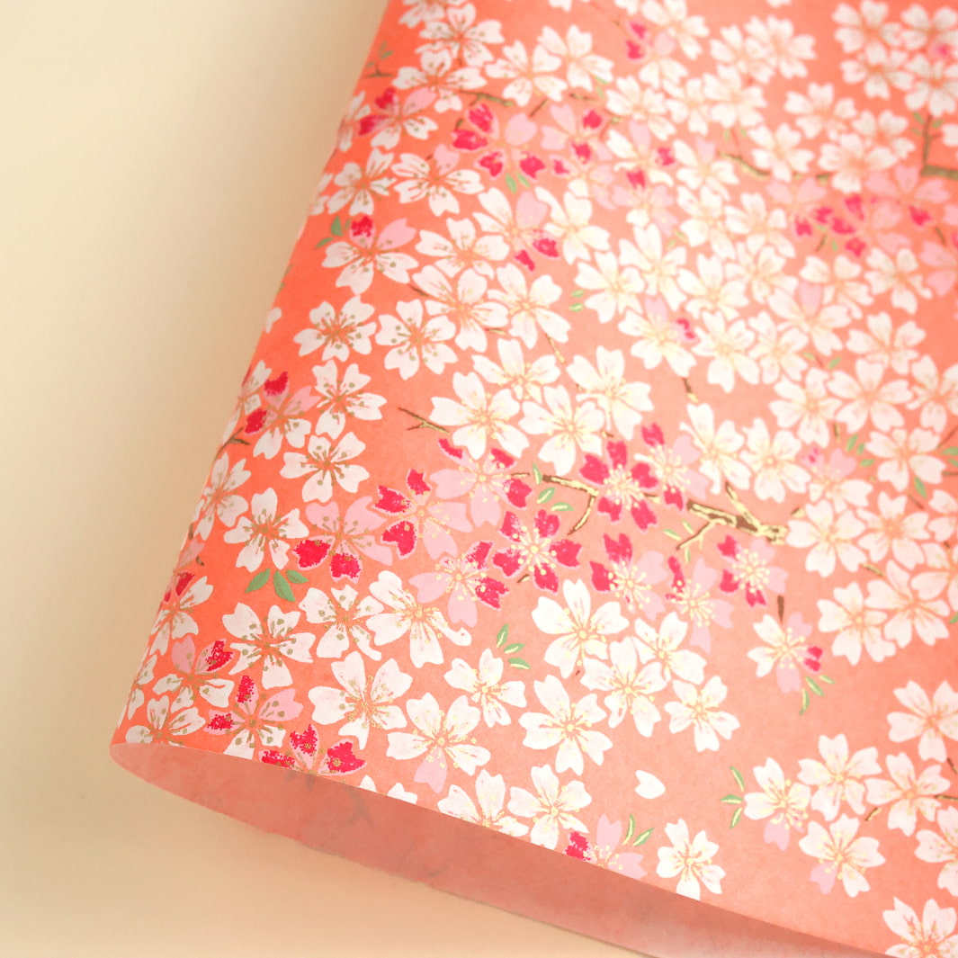 photo packshot d'une courbe de papier japonais yuzen chiyogami au motif de fleurs de cerisier dans les tons corail, blancs et rouge carmin adeline klam (M622)