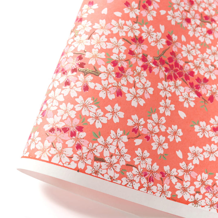 photo packshot d'une courbe de papier japonais yuzen chiyogami au motif de fleurs de cerisier dans les tons corail, rose pâle, rouge carmin et blancs adeline klam (M622)