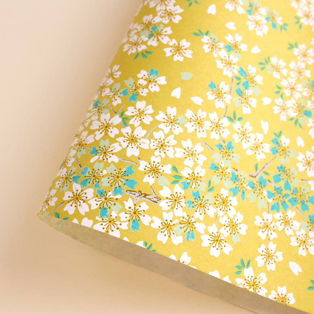photo packshot d'une courbe de papier japonais yuzen chiyogami au motif de fleurs de cerisier dans les tons jaune moutarde, vert d'eau et bleu turquoise adeline klam (M578)
