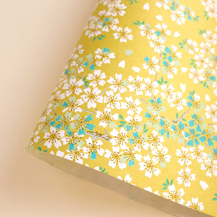 photo packshot d'une courbe de papier japonais yuzen chiyogami au motif de fleurs de cerisier dans les tons jaune moutarde, vert d'eau et bleu turquoise adeline klam (M578)