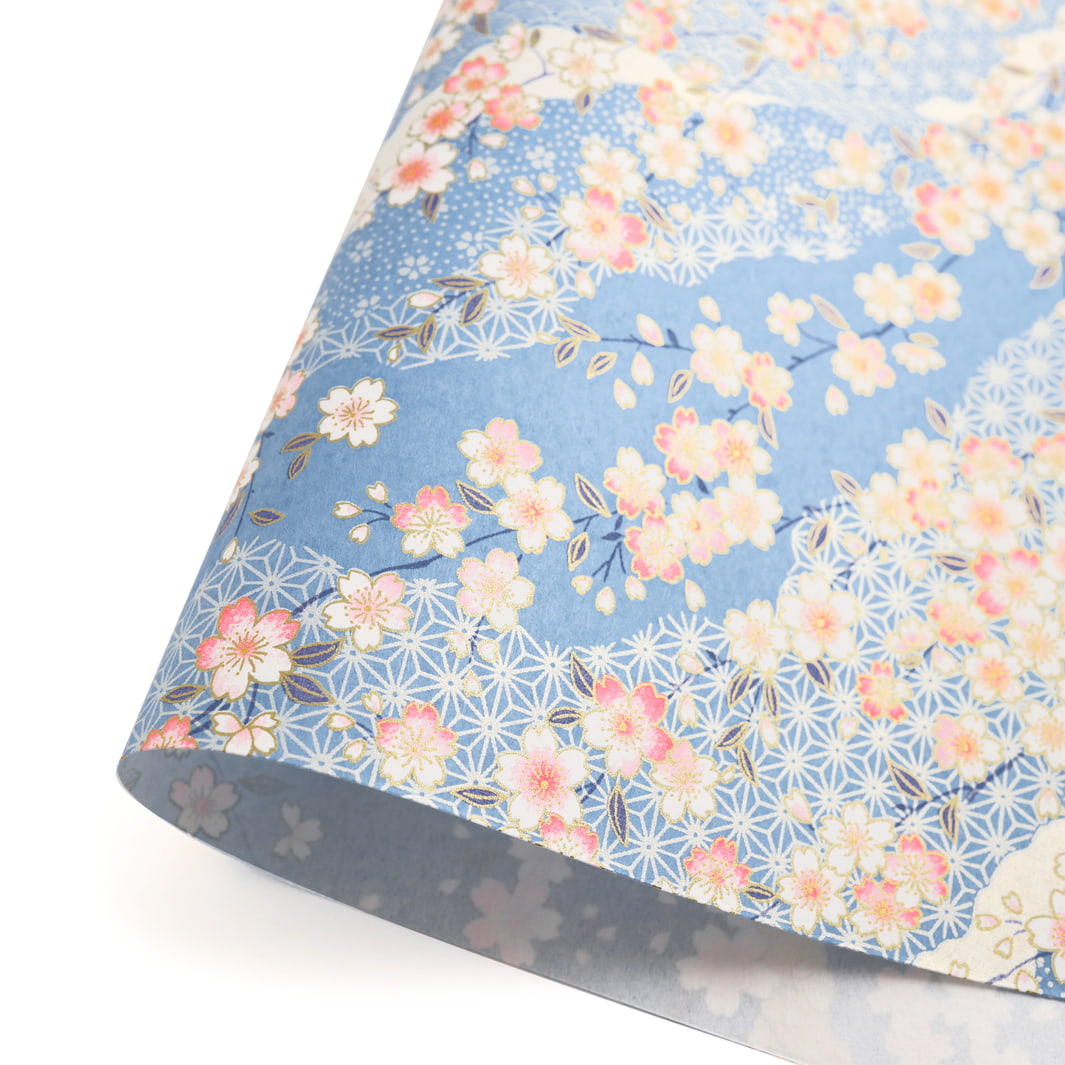 photo packshot d'une courbe de papier japonais yuzen chiyogami aux motifs de fleurs de cerisier et de motifs graphiques variés dans les tons bleu ciel adeline klam (M384)