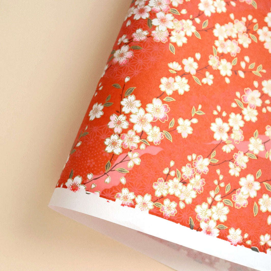 photo packshot d'une courbe de papier japonais yuzen chiyogami aux motifs de fleurs de cerisier et de motifs variés dans les tons rouge orange photo packshot d'une courbe de papier japonais yuzen chiyogami aux motifs de branches de cerisier et d'ondulations dans les tons bleu turquoise, rose fuchsia, jaune orange et dorés adeline klam (M385)