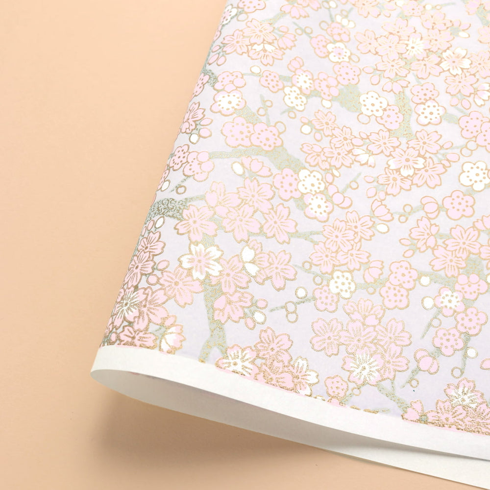 photo packshot d'une courbe du papier japonais yuzen chiyogami aux motifs de fleurs de cerisier et de prunier dans les tons rose clair, gris perle et blancs adeline klam (M901)