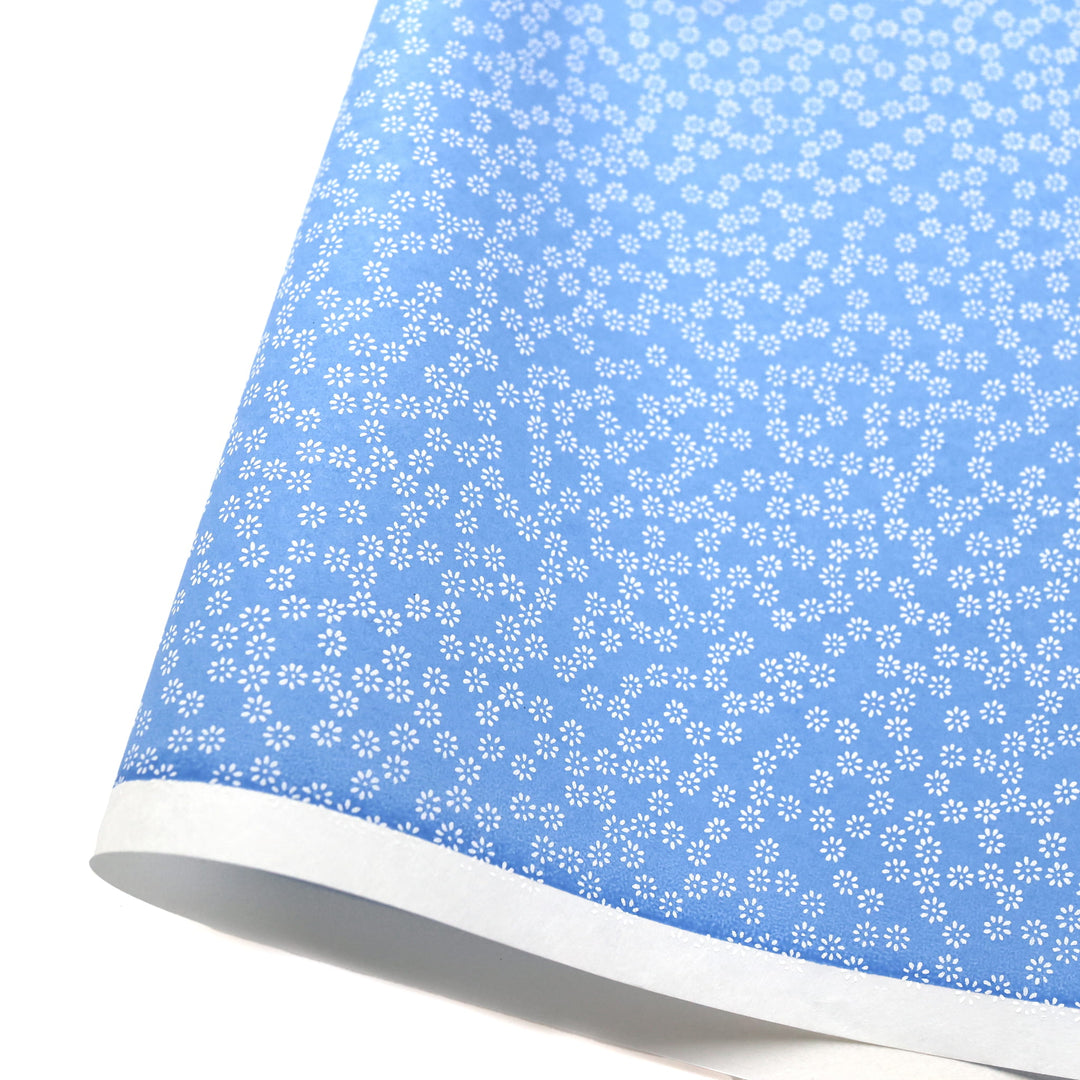 photo packshot d'une courbe de papier japonais yuzen chiyogami aux motifs de semi de fleurs blanches sur fondbleu pervenche adeline klam (M547)