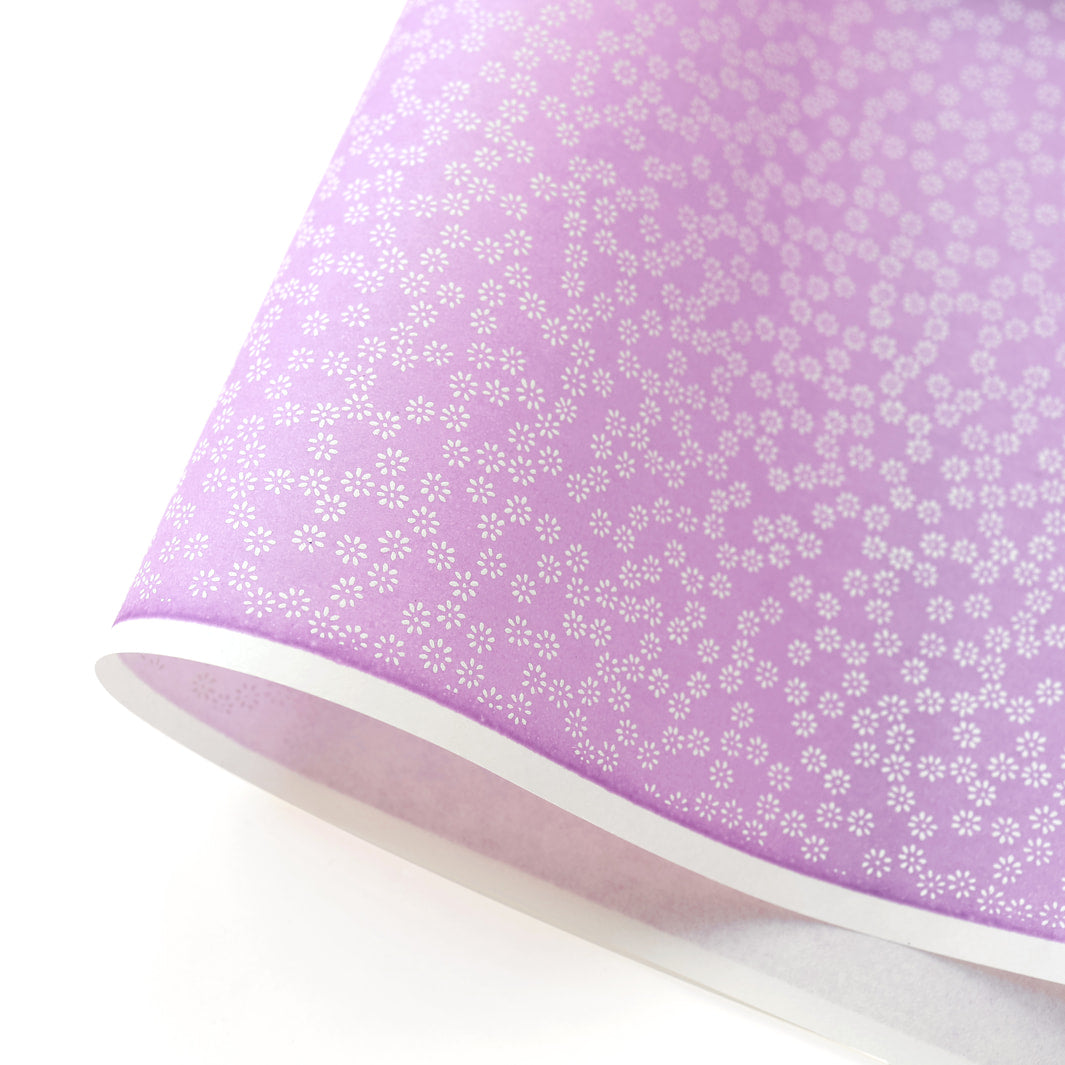 photo packshot d'une courbe de papier japonais yuzen chiyogami au motif de semi de fleurs blanches sur fond violet mauve adeline klam (M527)