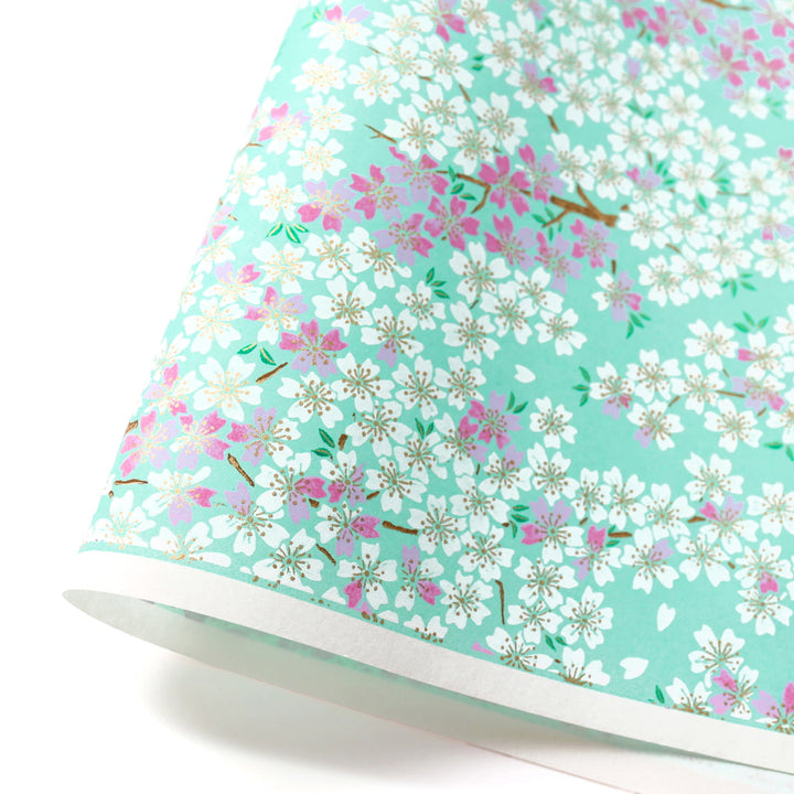 photo packshot d'une courbe de papier japonais yuzen chiyogami au motif de fleurs de cerisier dans les tons vert menthe, violet mauve et blancs adeline klam (M579)