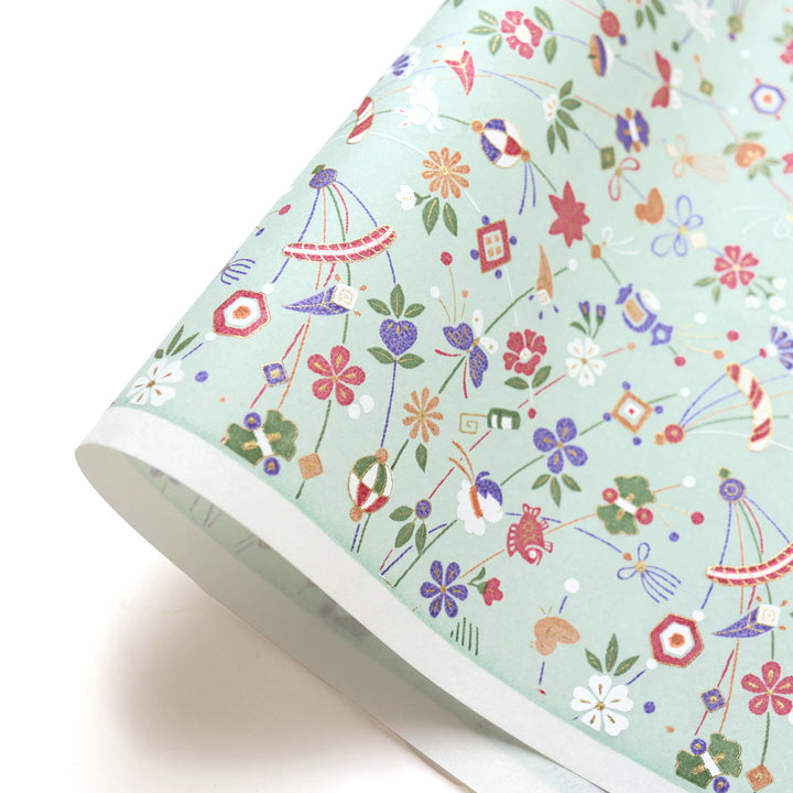 photo packshot d'une courbe de papier japonais yuzen chiyogami au motif de jouets japonais dans les tons vert de gris, bronzes, violets, verts et lie de vin adeline klam (M1068) 