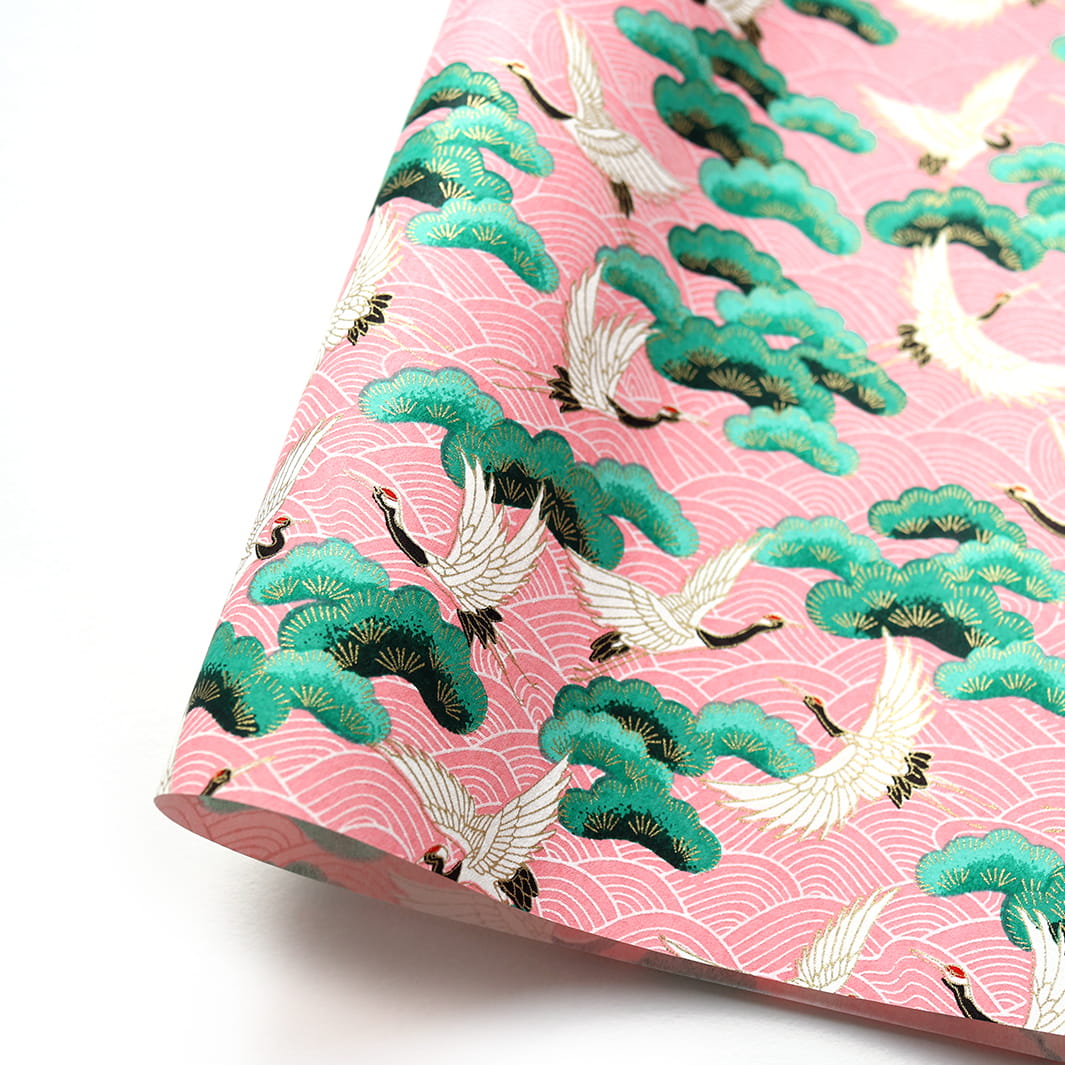 photo packshot d'une courbe de papier japonais yuzen chiyogami aux motifs de  grues, de pins et de vagues dans les tons roses, verts et blanc crème adeline klam (M686)