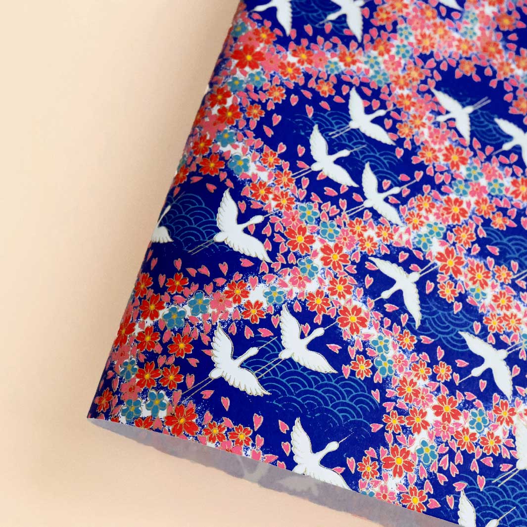 photo packshot d'une courbe de papier japonais yuzen chiyogami aux motifs de grues, de vagues et de fleurs dans les tons bleu foncé et turquoise, rouges, roses et blancs adeline klam (M876)