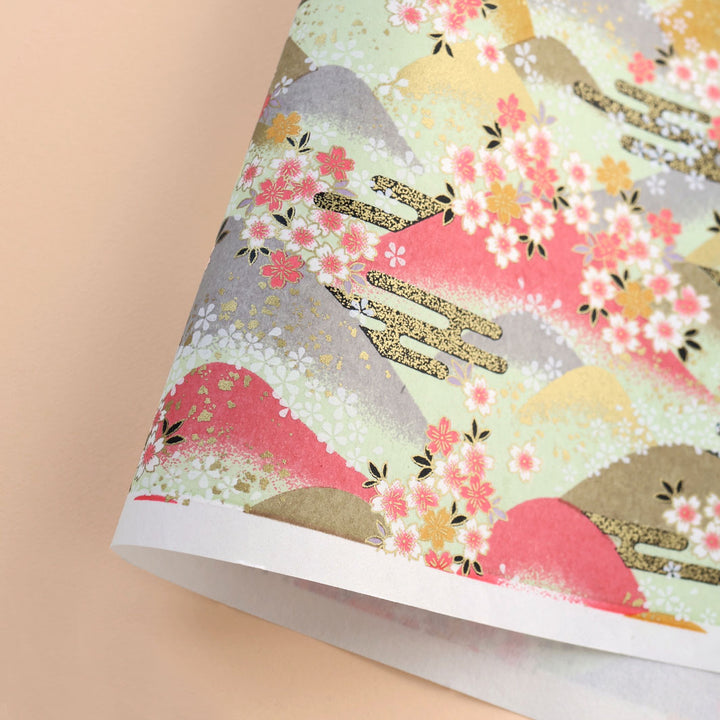 photo packshot d'une courbe de papier japonais yuzen chiyogami aux motifs de montagnes et de fleurs de cerisier dans les tons bois de rose, jaune moutarde, vert amande, gris et dorés adeline klam (M1033)