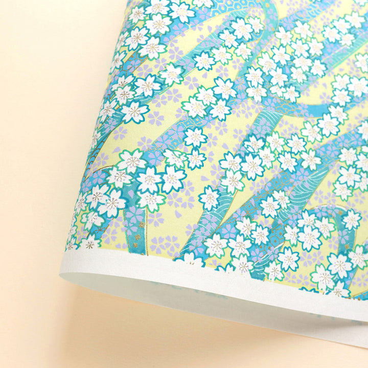 photo packshot d'une courbe de papier japonais yuzen chiyogami aux motifs d'ondulations fleuries dans les tons jaune clair, bleu moyen, vert d'eau, parme et dorés adeline klam (M1021)