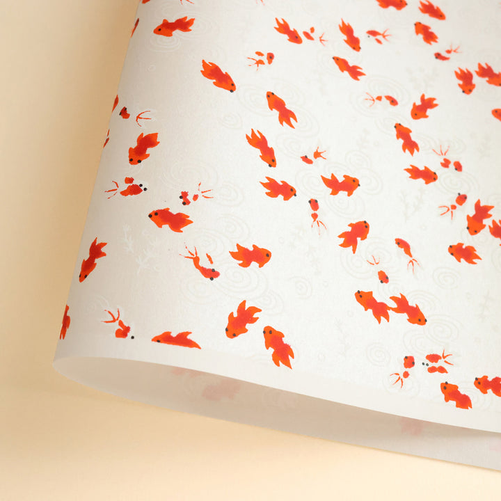 photo packshot d'une courbe de papier japonais yuzen chiyogami au motif de poissons rouges sur fond blanc nacré adeline klam (M613)