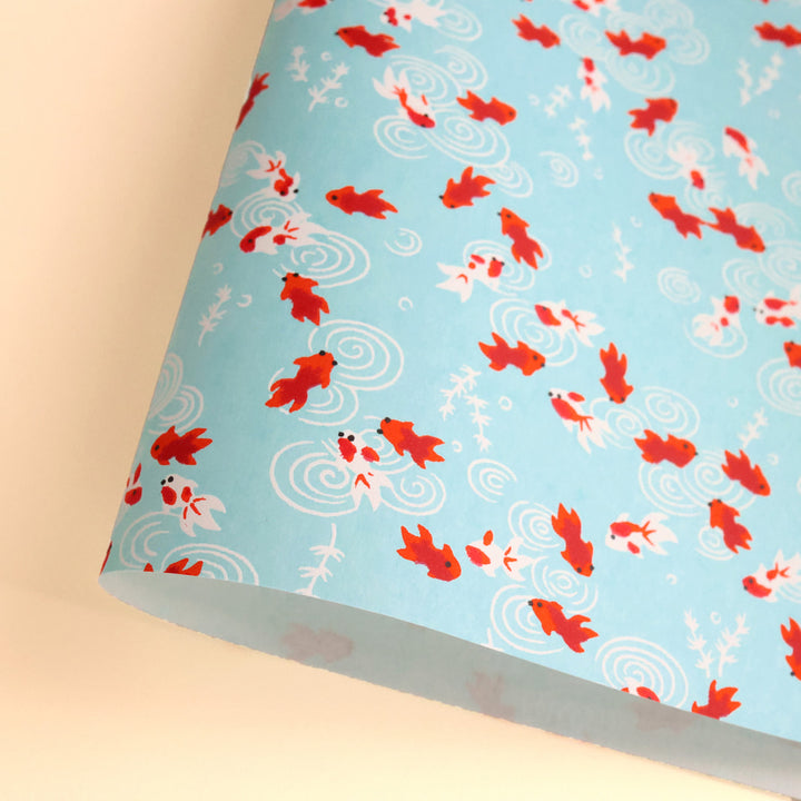 photo packshot d'une courbe de papier japonais yuzen chiyogami au motif de poissons rouges sur fond bleu ciel adeline klam (M890)