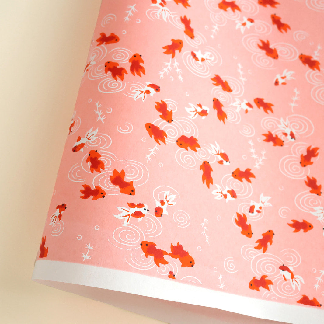 photo packshot d'une courbe de papier japonais yuzen chiyogami au motif de poissons rouges sur fond rose adeline klam (M136)