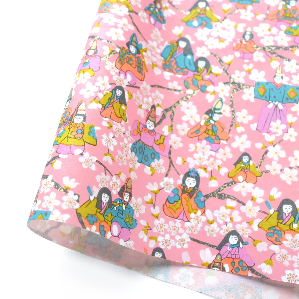 photo packshot d'une courbe de papier japonais yuzen chiyogami aux motifs de poupées d'hina matsuri et de fleurs de pêcher dans les rose clair et moyen, corail, bleu gris et vert jaune adeline klam (M1065)