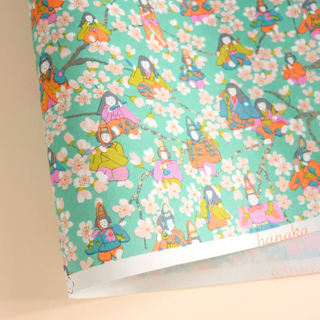 photo packshot d'une courbe de papier japonais yuzen chiyogami au motif de poupées de hina matsuri et de fleurs de pêcher dans les tonsvert menthe, rose mauve, orange clair, vert acidulé et bleu adeline klam (M1004)