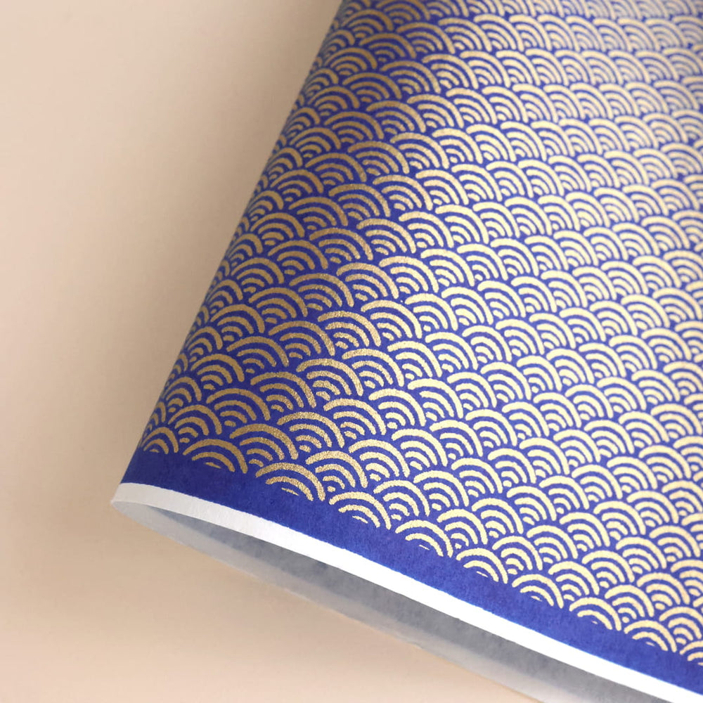 photo packshot d'une courbe de papier japonais yuzen chiyogami aux motifs de vagues inversées dans les tons bleu nuit et dorés (M755)