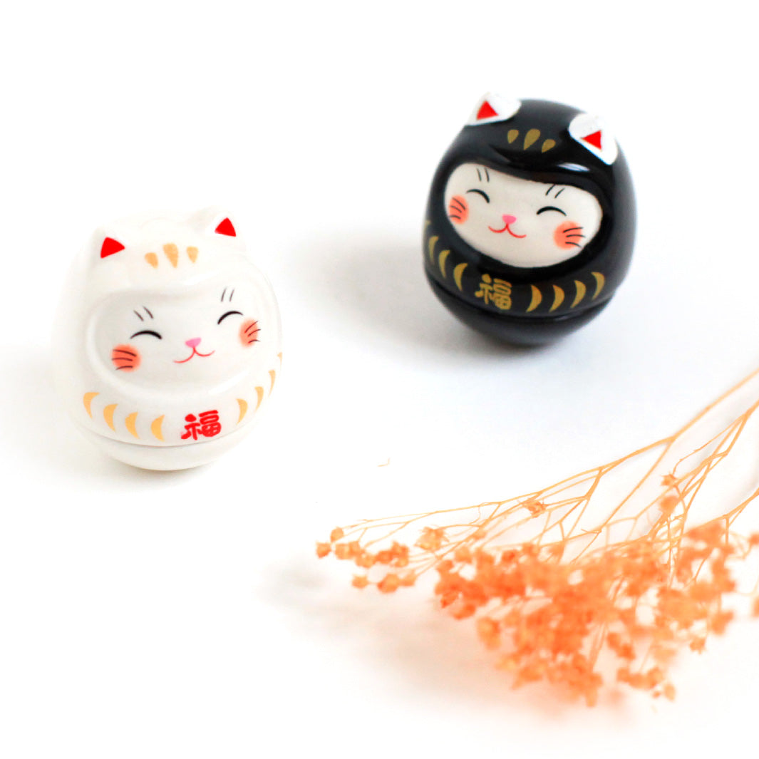 photo packshot de culbutos japonais (ou kororin) en céramique en forme de daruma chat blanc et noir
