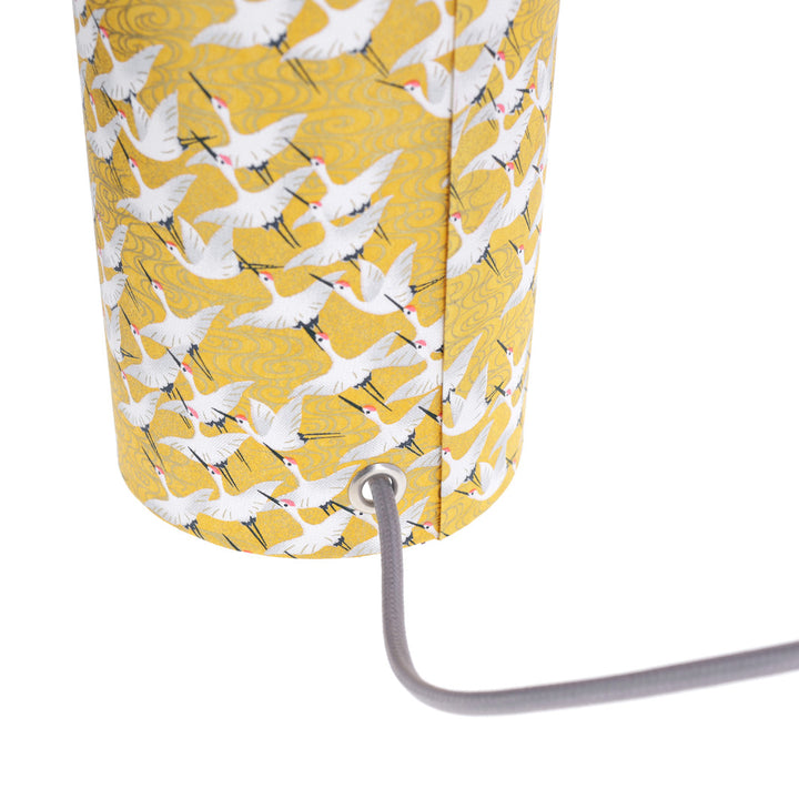 photo packshot d'un détail du câble électrique gris de la lampe japonaise à poser aux motifs d'envolée de grues blanches sur fond jaune moutarde (M930) adeline klam