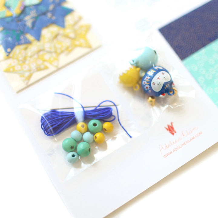 photo packshot du détail du fil, des perles et des stickers du kit guirlande porte-bonheur bleu roi, vert d'eau et jaune moutarde « luciole » adeline klam