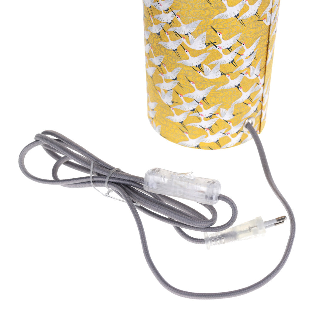 photo packshot d'un détailde l'interrupteur gris de la lampe japonaise à poser aux motifs d'envolée de grues blanches sur fond jaune moutarde (M930) adeline klam
