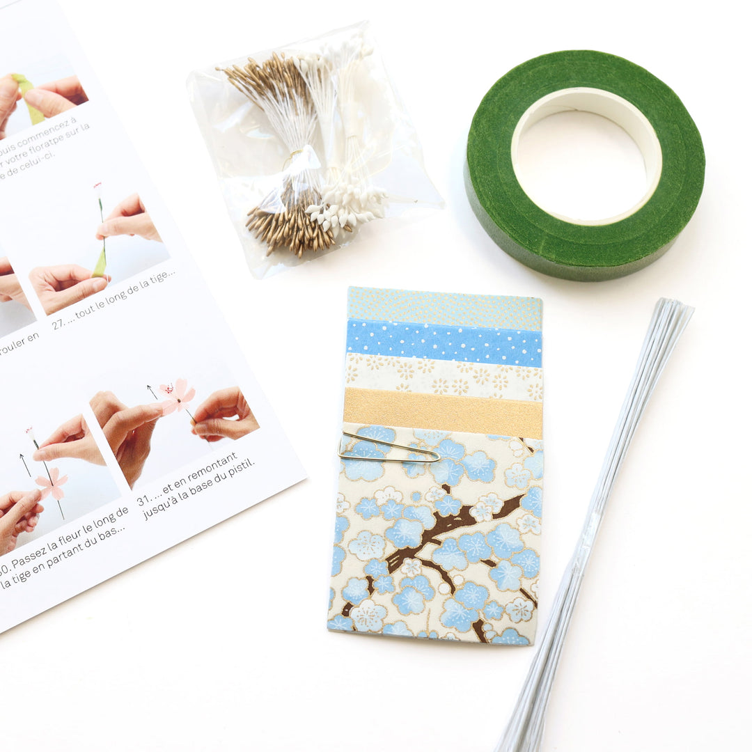 photo packshot d'un détail du livret explicatif et du matériel du kit bouquet de fleurs de cerisier dans les tons bleu ciel, dorés et blanc crème « neige » adeline klam