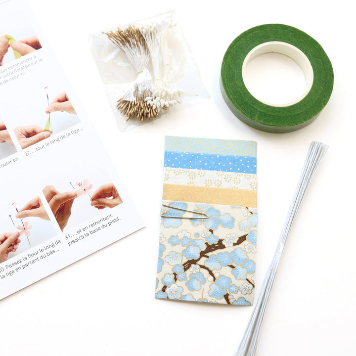 photo packshot d'un détail du livret explicatif et du matériel du kit bouquet de fleurs de cerisier dans les tons bleu ciel, dorés et blanc crème « neige » adeline klam