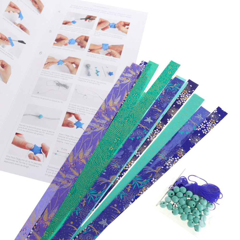 photo packshot d'un détail du matériel et du dépliant du kit guirlande d'étoiles « libellule » dans les tons bleu nuit, bleu turquoise, vert d'eau et verts adeline klam