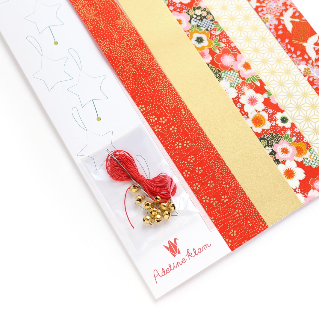 photo packshot d'un détail du packaging du kit étoiles à suspendre dans les tons rouge orange, blancs et doré « rubis » adeline klam