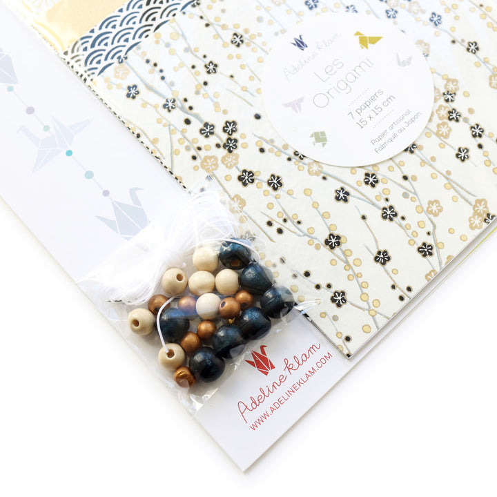 photo packshot d'un détail du packaging du kit guirlande de grues en origami dans les tons blanc crème, noirs et dorés « manuscrit » S4 adeline klam 