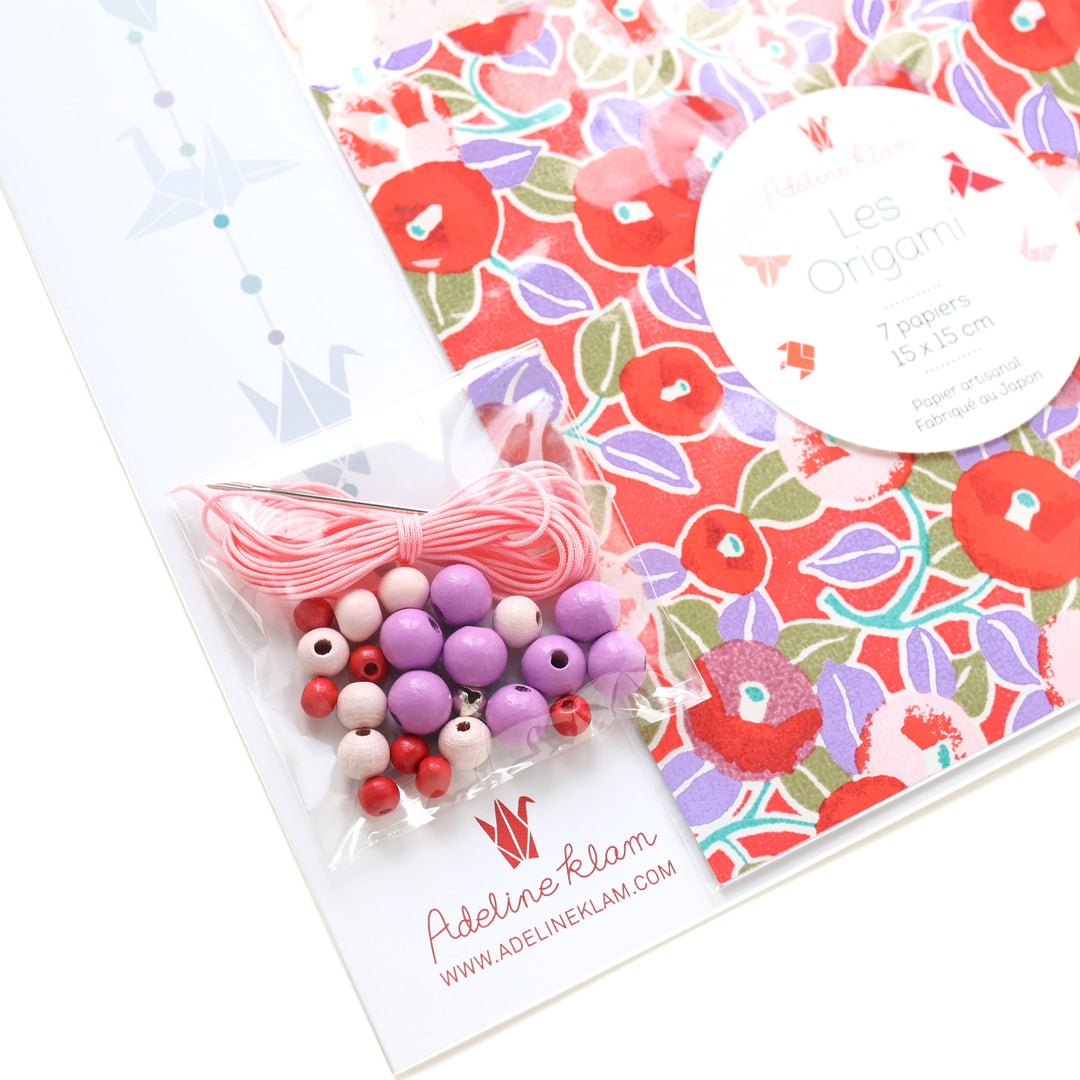 photo packshot d'un détail du packaing du kit guirlande de grues en origami dans les tons rouge rose, violet mauve, orange pastel et vert menthe de la gamme « hibiscus » (C9) adeline klam