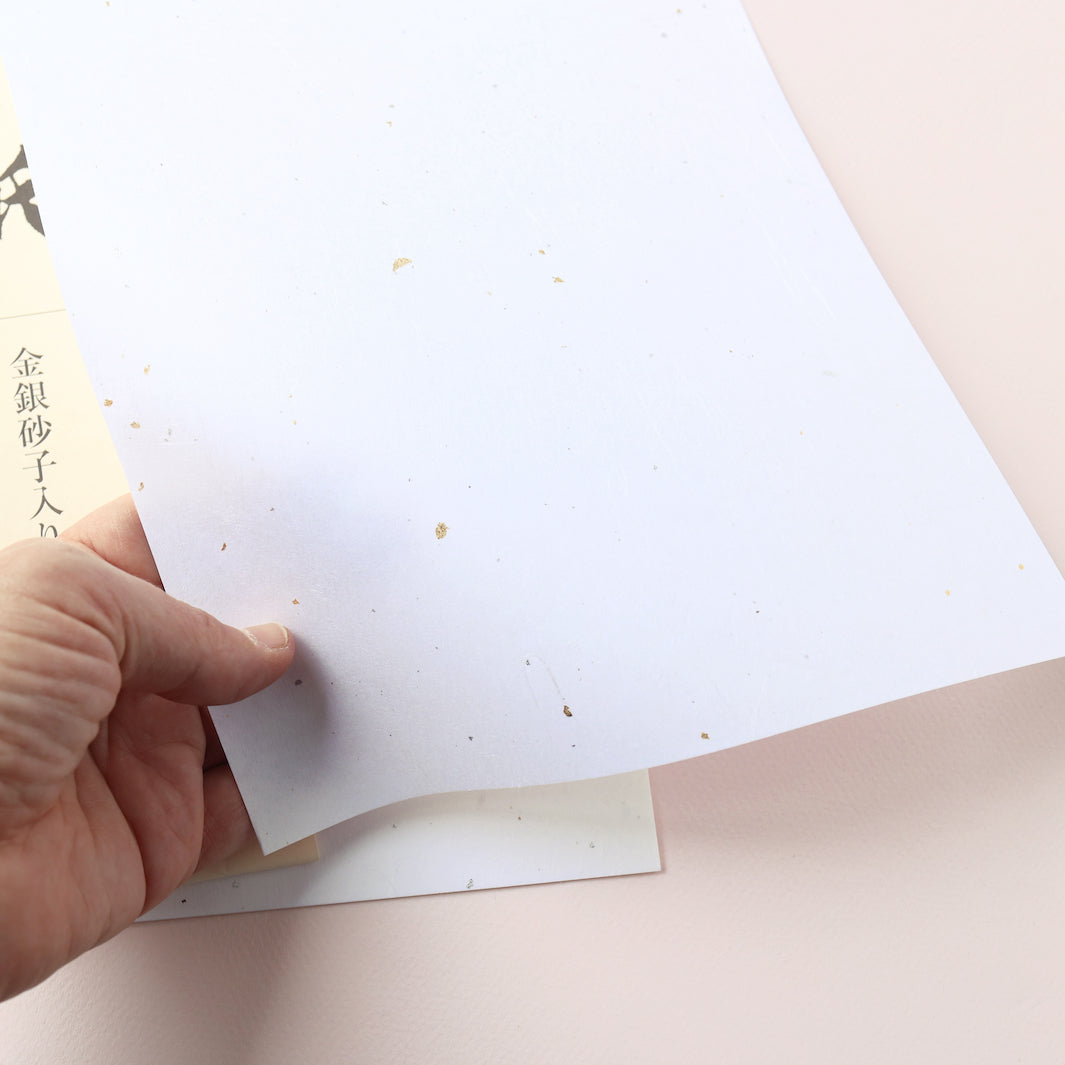 photo packshot d'un détail de la texture du papier du bloc de 10 papiers blancs « shinzukushi » aux inscrustations unryu dorées et argentées de 210 par 297mm